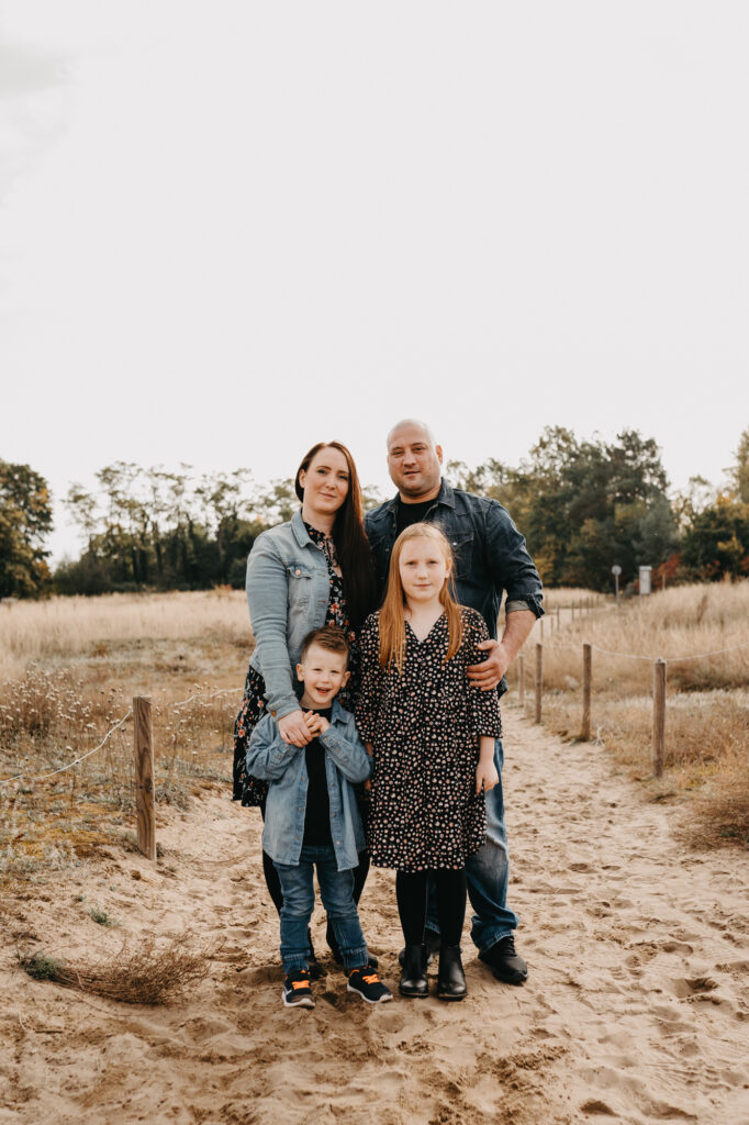 Familie mit zwei Kindern bei einem Fotoshooting im Freien